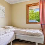 Two single beds with white bedding. Window with curtains and wall art.