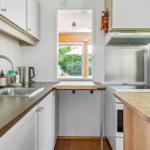 Kitchen with countertops, sink, stove, and window to the garden.