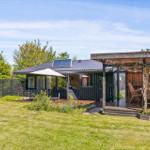 House with terrace, grill and parasol in the garden.