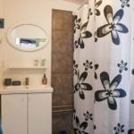 Bathroom with shower curtain, sink, and mirror.