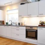 Kitchen with white cabinets, countertop, and built-in oven.