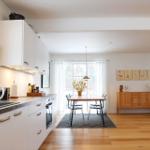 Kitchen with dining area and living room with hardwood floors and windows.