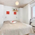 Bedroom with bed, white closets, and large window with view.