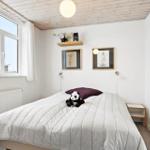 Bedroom with bed, window, wall art, and wall lamp.