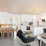 Open space with kitchen, dining area, and seating. Wooden ceiling and modern furnishings.