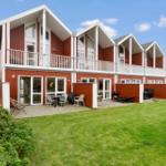 Red vacation house with balcony and garden. Outdoor terrace with seating.