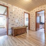 Raum mit Holzboden und Fliesenwand. Durchgänge zu Wohnzimmer, Schlafzimmer und Bad.