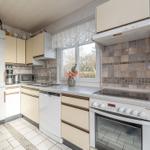 Küche mit Arbeitsplatte, Herd, Spüle und Fenster.