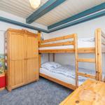 Zimmer mit Doppelstockbett, Kleiderschrank und Spielzeug.