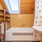 Bad mit Badewanne, Duschkabine und Waschbecken unter Dachschrägen.