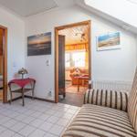 Wohnbereich mit Sofa, Bad und Schlafzimmer. Wandbild und Kalender an der Wand.