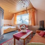 Schlafzimmer mit Bett, Kleiderschrank und Wohnbereich mit Sofa und Fernseher.