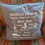 Kissen mit nordischer Motivierung auf einem gemusterten Sofa