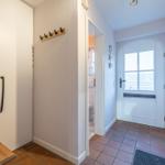 Eingangsbereich mit Garderobe, Haken und Blick in die Toilette.