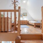 Ein Schlafzimmer mit zwei Betten, Holzboden und einem Kleiderständer.