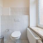 Badezimmer mit Toilette, Fenster und Heizkörper
