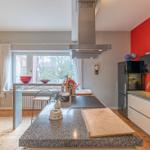 Küche mit Insel, roter Wand und Blick in Esszimmer.