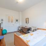 Ein Schlafzimmer mit Bett, Tisch, Stühlen und einer Tür.