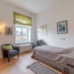 Schlafzimmer mit Bett, Schreibtisch, Stuhl und Holzschrank. Fenster mit grünem Rollladen.