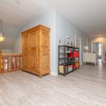 Hallenraum mit Holzschrank, Regal und Koffer. Holzboden und Wandfarbe.