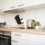 Küche mit Arbeitsplatte, Spüle, Herd und Kaffeemaschine.