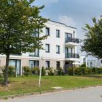 Moderne Wohnung mit Balkon, begrünter Außenbereich und Bäumen