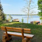Holzbank am Seeufer mit Blick auf Wasser und Bäume.