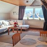 Wohn- und Essbereich mit Sofa, Tisch und Fensterblick.