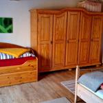 Zwei Betten und ein großer Holzschrank im Schlafzimmer.