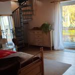 Schlafzimmer mit Bett, Schrank und Glasfront zur Terrasse