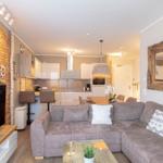 Wohnzimmer mit Sofa, Couchtisch und Küchenbereich im Hintergrund.