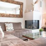 Wohnzimmer mit Sofa, Kamin und Glas-Tisch