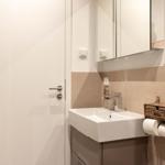 Badezimmer mit Waschbecken, Spiegel und Handtuchhalter