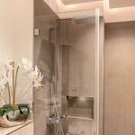 Dusche mit Glaswand und Orchidee auf Ablagefläche