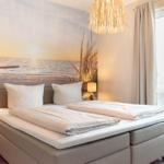 Schlafzimmer mit Bett, Wandbild und Balkontür