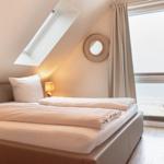 Schlafzimmer mit Dachschrägen, Dachfenster und Blick aufs Meer.