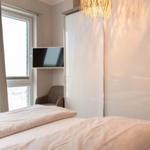 Schlafzimmer mit Bett, Fenster, TV und Schwebetüren