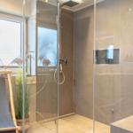 Duschkabine mit Glaswand, Fenster und Badezimmermöbel