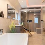 Badezimmer mit Badewanne, Dusche und Glaswand