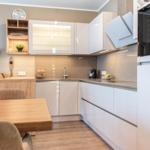 Moderne Küche mit weißen Schränken und Holztisch