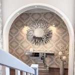 Eingangsbereich mit Bogen, Wandspiegel und Konsole.