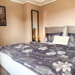 Schlafzimmer mit Bett, Wandspiegel und Wandbild mit Hirschmotiv.