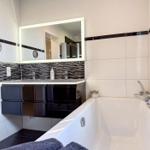 Badezimmer mit Badewanne, Waschbecken und Spiegel