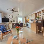 Living and kitchen area with dining table, seating, and kitchen cabinets.