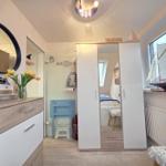 Bedroom with wardrobe, mirror, and view of sailboat model.