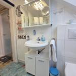 Bathroom with sink, mirror, shower, and toilet.