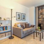 Ein Wohnzimmer mit Sofa, Beistelltisch, Bücherregal und Schrank.