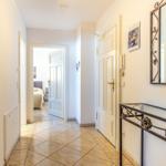 Flur mit Tür zu Schlafzimmer, Spiegel und Dekorationsstück.