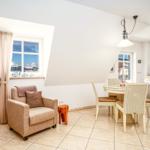 Wohn- und Essbereich mit Sitzgelegenheit, Esstisch und Küche. Fenster mit Blick auf Schnee.