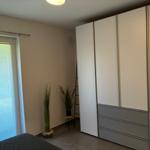 Schlafzimmer mit Kleiderschrank, Fenster und Pflanzen.